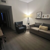 Cozy living room with a sofa, armchair, and warm lighting.