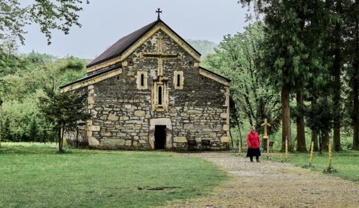 Old stone chapel surrounded by trees.